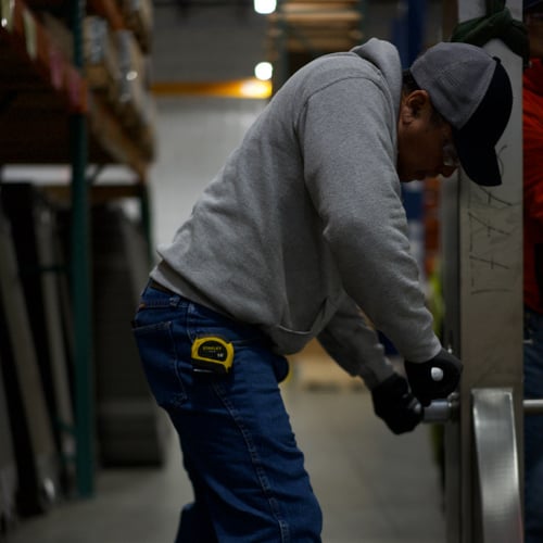 AGC service worker tightening bolt on plate heat exchanger frame.