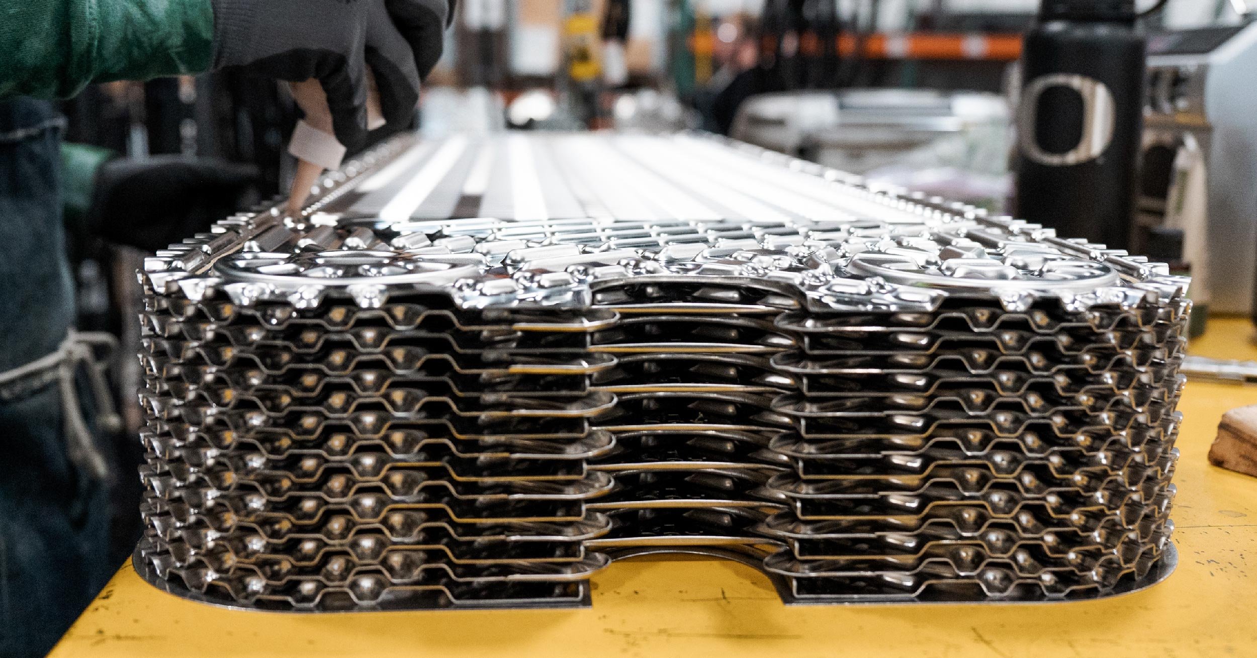 Stack of AGC plate heat exchanger plates lay on table